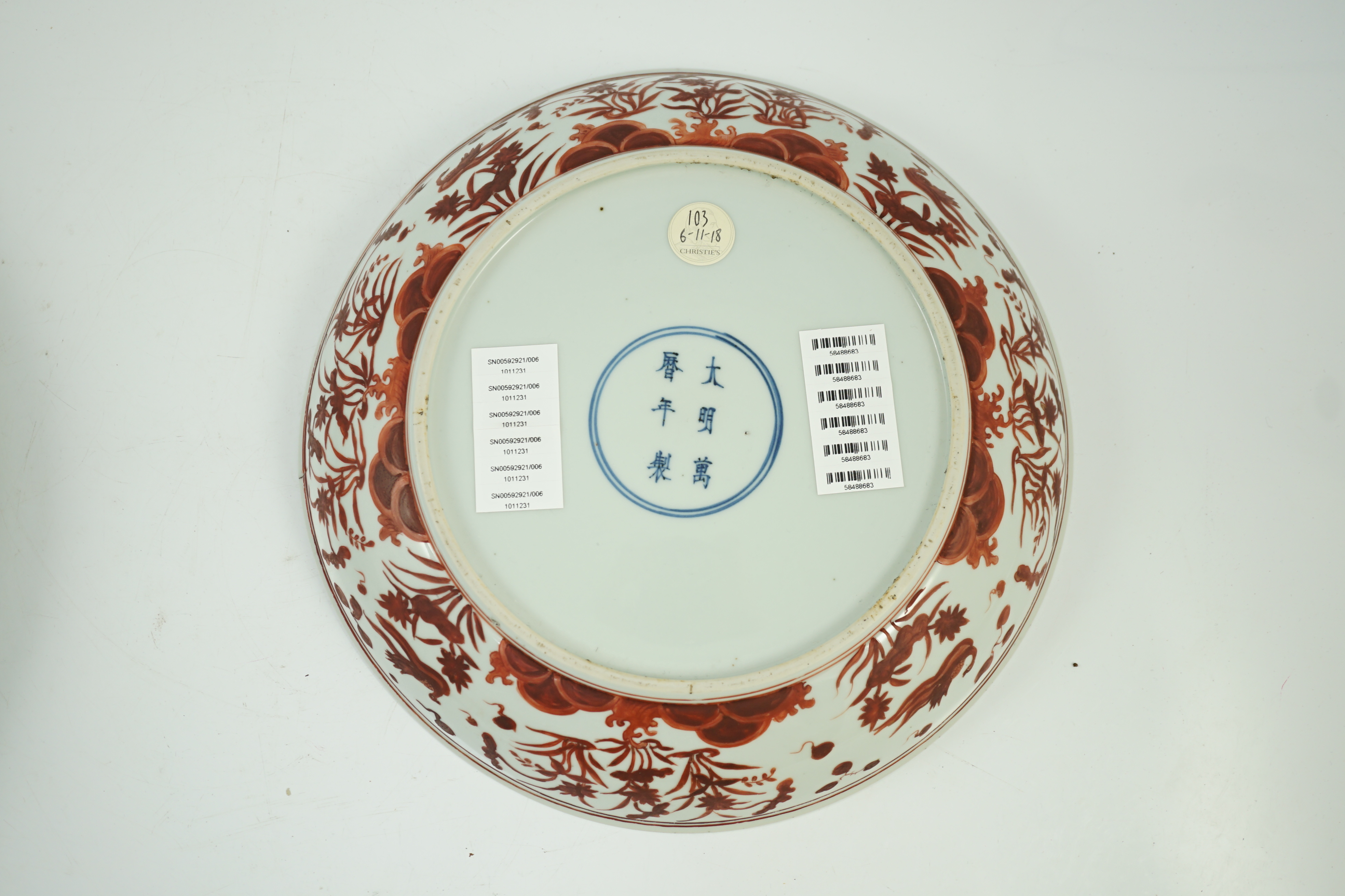 A large Chinese iron red enamelled ‘lotus pond’ dish, Wanli mark and possibly of the period, two short cracks